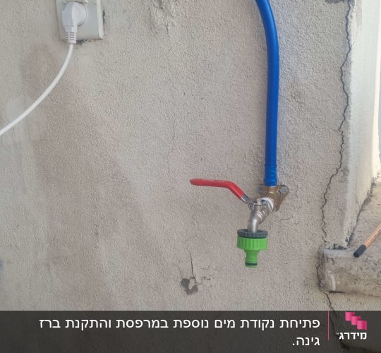 ברז מים מותקן על קיר עם צינור כחול